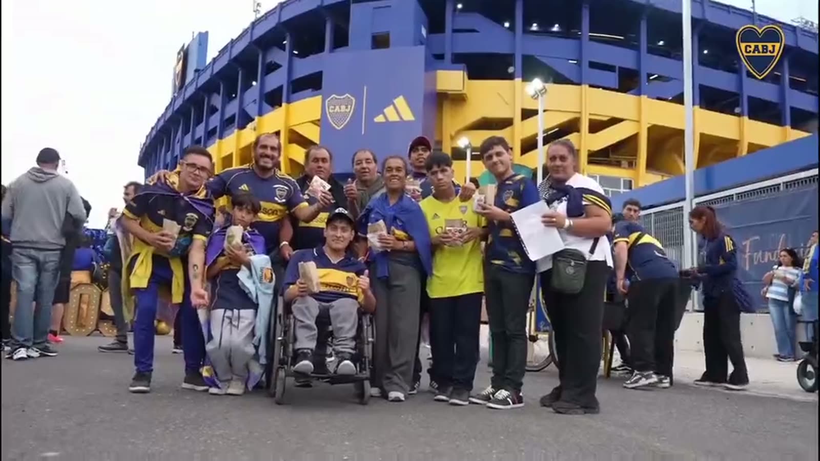 Dos chicos con la cara pintada de azul y oro se abrazan en el encuentro de la Fundación con las familias